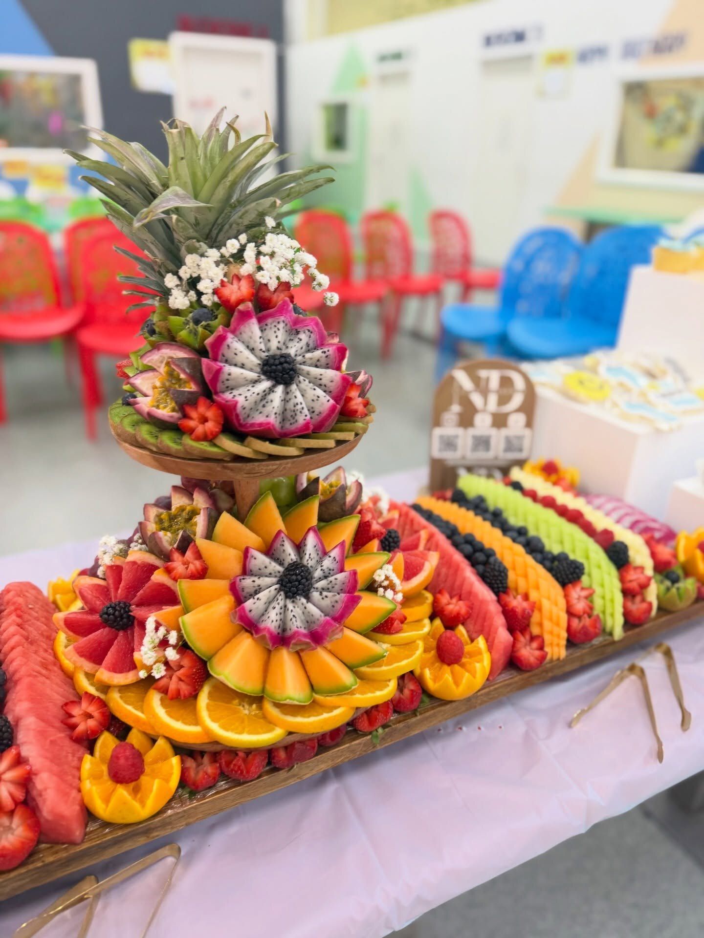 A Signature Fruit Board with a carved tier for a first birthday